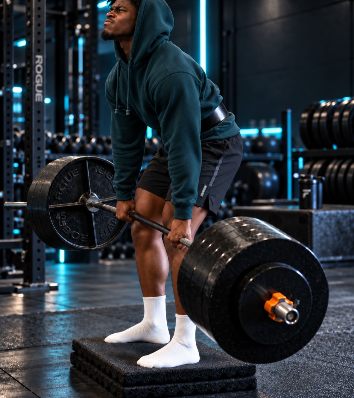 side-on view of lifter performing deficit deadlift from 3cm platform, lower starting position visible, hip and back angle comparison shown against standard setup in the same frame